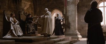 Movie still from “Robin Hood” (2010), directed by Ridley Scott – A priest and a nun are standing in front of a throne; Wide shot, Low angle