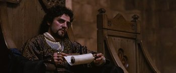 Movie still from “Robin Hood” (2010), directed by Ridley Scott – A man sitting in a chair holding a roll of toilet paper; Close Up shot, Low angle