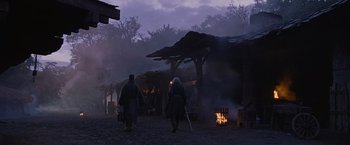 Movie still from “Robin Hood” (2010), directed by Ridley Scott – A couple of people walking down a dirt road; Wide shot, Low angle