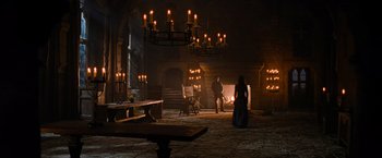 Movie still from “Robin Hood” (2010), directed by Ridley Scott – A woman and a man are standing in a dark room; Wide shot, High angle
