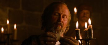 Movie still from “Robin Hood” (2010), directed by Ridley Scott – A man with a beard is holding a piece of paper in his hands; Close Up shot, Low angle