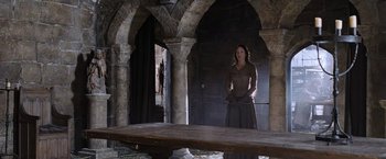 Movie still from “Robin Hood” (2010), directed by Ridley Scott – A woman standing in an archway in an old building; Wide shot, Low angle
