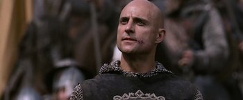 Movie still from “Robin Hood” (2010), directed by Ridley Scott – A bald man with a scar on his face; Close Up shot, Low angle