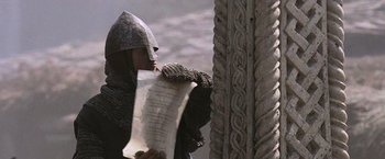 Movie still from “Robin Hood” (2010), directed by Ridley Scott – A person in a helmet holding a paper; Close Up shot, Low angle