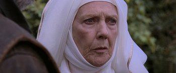 Movie still from “Robin Hood” (2010), directed by Ridley Scott – An old woman wearing a head covering and looking at the camera; Close Up shot, Low angle