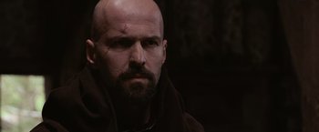 Movie still from “Robin Hood” (2010), directed by Ridley Scott – A man with a beard and a shaved head looking at the camera; Close Up shot, Over the shoulder angle
