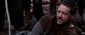 Movie still from “Robin Hood” (2010), directed by Ridley Scott – A man with a beard is sitting in the dirt; Close Up shot, Over the shoulder angle