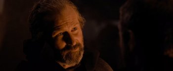Movie still from “Robin Hood” (2010), directed by Ridley Scott – An old man with a beard is smiling for the camera; Close Up shot, Over the shoulder angle