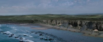 Movie still from “Robin Hood” (2010), directed by Ridley Scott – An aerial view of a body of water with a cliff in the background; Extreme Wide shot, High angle