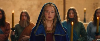 Movie still from “Benedetta” (2021), directed by Paul Verhoeven – A woman wearing a blue mantle and a red dress; Close Up shot, Low angle