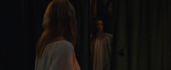 Movie still from “Benedetta” (2021), directed by Paul Verhoeven – A woman standing in front of a mirror looking at her reflection; Medium shot, Over the shoulder angle