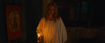 Movie still from “Benedetta” (2021), directed by Paul Verhoeven – A woman holding a lit candle in a dark room; Medium shot, High angle