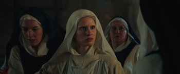 Movie still from “Benedetta” (2021), directed by Paul Verhoeven – A woman in a nun's outfit looking into the camera; Close Up shot, Low angle