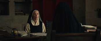 Movie still from “Benedetta” (2021), directed by Paul Verhoeven – A nun looking in the mirror in front of a mirror; Medium shot, Over the shoulder angle
