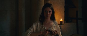 Movie still from “Benedetta” (2021), directed by Paul Verhoeven – A woman holding a knife in her hand; Medium shot, Over the shoulder angle