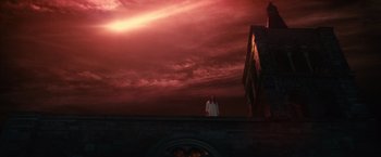 Movie still from “Benedetta” (2021), directed by Paul Verhoeven – A person standing on a roof under a cloudy sky; Extreme Wide shot, Low angle