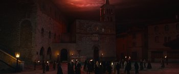 Movie still from “Benedetta” (2021), directed by Paul Verhoeven – A group of people walking in front of a building; Extreme Wide shot, Low angle