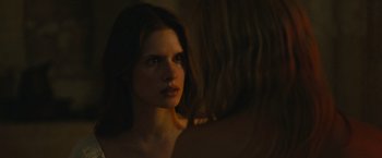 Movie still from “Benedetta” (2021), directed by Paul Verhoeven – A beautiful young woman with long dark brown hair; Close Up shot, Over the shoulder angle