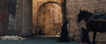 Movie still from “Benedetta” (2021), directed by Paul Verhoeven – A man in a black robe walking down a street; Extreme Wide shot, High angle