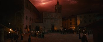 Movie still from “Benedetta” (2021), directed by Paul Verhoeven – A group of people gathered in front of a building; Extreme Wide shot, High angle