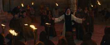 Movie still from “Benedetta” (2021), directed by Paul Verhoeven – A nun is standing in front of a group of people; Wide shot, High angle