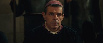 Movie still from “Benedetta” (2021), directed by Paul Verhoeven – A person wearing a hat; Close Up shot, Over the shoulder angle