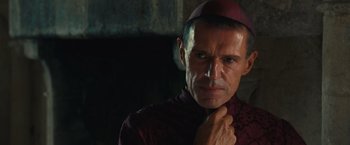 Movie still from “Benedetta” (2021), directed by Paul Verhoeven – A person wearing a hat; Close Up shot, Over the shoulder angle