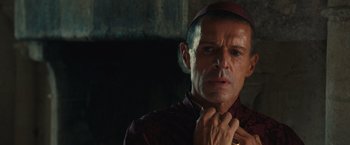 Movie still from “Benedetta” (2021), directed by Paul Verhoeven – A person wearing a hat; Close Up shot, Over the shoulder angle