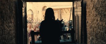Movie still from “Benedetta” (2021), directed by Paul Verhoeven – A woman standing in front of a group of people; Wide shot, Over the shoulder angle