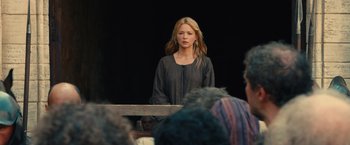 Movie still from “Benedetta” (2021), directed by Paul Verhoeven – A woman standing in front of a group of people; Medium shot, Over the shoulder angle