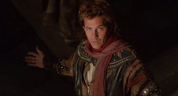 Movie still from “Robin Hood: Prince of Thieves” (1991), directed by Kevin Reynolds – A man wearing a leather jacket and a scarf; Medium shot, Low angle