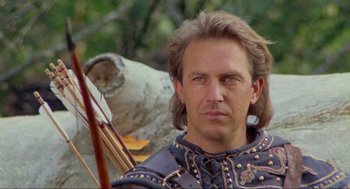 Movie still from “Robin Hood: Prince of Thieves” (1991), directed by Kevin Reynolds – A person holding a bow and arrow; Close Up shot, Low angle