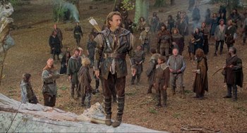 Movie still from “Robin Hood: Prince of Thieves” (1991), directed by Kevin Reynolds – A group of people standing in a forest; Wide shot, Low angle