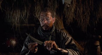 Movie still from “Robin Hood: Prince of Thieves” (1991), directed by Kevin Reynolds – A man holding a knife in his hands; Close Up shot, Over the shoulder angle