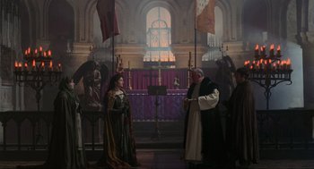Movie still from “Robin Hood: Prince of Thieves” (1991), directed by Kevin Reynolds – A woman and a priest in a church with flags; Wide shot, High angle