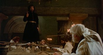 Movie still from “Robin Hood: Prince of Thieves” (1991), directed by Kevin Reynolds – A group of people sitting around a table; Wide shot, Low angle