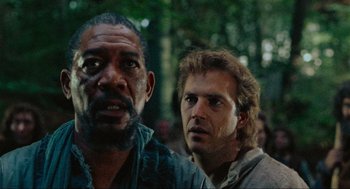 Movie still from “Robin Hood: Prince of Thieves” (1991), directed by Kevin Reynolds – Two men standing next to each other in a forest; Close Up shot, Low angle