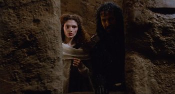 Movie still from “Robin Hood: Prince of Thieves” (1991), directed by Kevin Reynolds – A man and a woman standing next to each other; Medium shot, Low angle