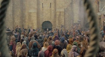 Movie still from “Robin Hood: Prince of Thieves” (1991), directed by Kevin Reynolds – A crowd of people standing in front of a stone building; Extreme Wide shot, High angle