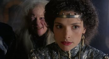 Movie still from “Robin Hood: Prince of Thieves” (1991), directed by Kevin Reynolds – A woman in a silver and black dress and a man in a white and black suit; Close Up shot, Over the shoulder angle