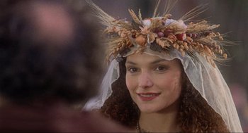 Movie still from “Robin Hood: Prince of Thieves” (1991), directed by Kevin Reynolds – A woman wearing a wreath of flowers and a veil; Close Up shot, Over the shoulder angle