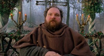 Movie still from “Robin Hood: Prince of Thieves” (1991), directed by Kevin Reynolds – A man with a beard wearing a brown robe; Medium shot, Low angle