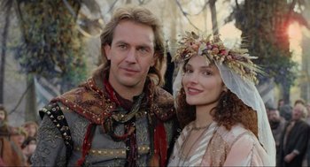 Movie still from “Robin Hood: Prince of Thieves” (1991), directed by Kevin Reynolds – A man and a woman standing next to each other; Close Up shot, Low angle