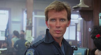 Movie still from “RoboCop” (1987), directed by Paul Verhoeven – A man in a police uniform looking at the camera; Close Up shot, Low angle