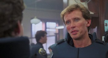 Movie still from “RoboCop” (1987), directed by Paul Verhoeven – A person wearing a suit; Close Up shot, Over the shoulder angle