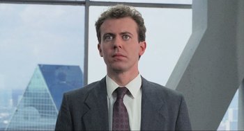 Movie still from “RoboCop” (1987), directed by Paul Verhoeven – A person wearing a suit and tie; Close Up shot, Low angle