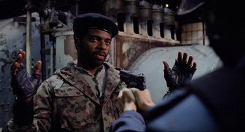 Movie still from “RoboCop” (1987), directed by Paul Verhoeven – A man in a military uniform is taking a picture of another man; Close Up shot, Over the shoulder angle