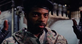 Movie still from “RoboCop” (1987), directed by Paul Verhoeven – A man wearing a hat and a camouflage jacket; Close Up shot, Low angle