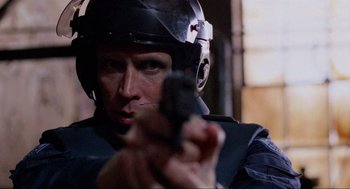 Movie still from “RoboCop” (1987), directed by Paul Verhoeven – A man in a helmet is holding a gun; Close Up shot, Over the shoulder angle