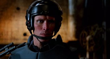 Movie still from “RoboCop” (1987), directed by Paul Verhoeven – A man wearing a helmet is looking into the distance; Close Up shot, Over the shoulder angle